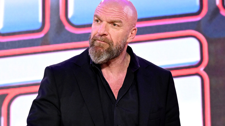 Triple H looks on.